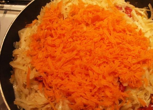 1. Этап. Постная солянка из свежей капусты: Добавьте помидоры, тертую морковь, соль и перец.