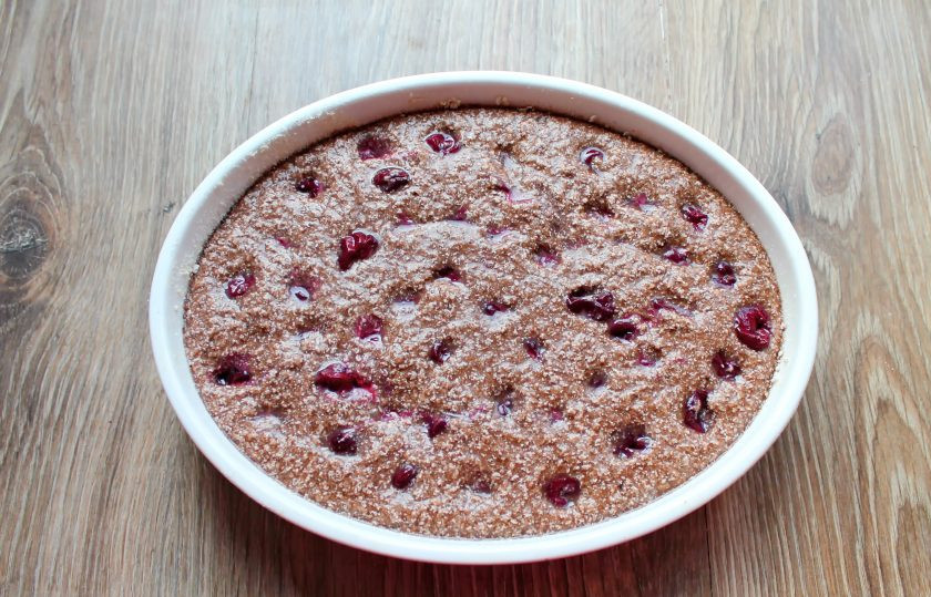 1. Этап. Шоколадный манник с вишней: Переложите тесто в форму диаметром 22-24 сантиметра и разровняйте. Утопите вишню по всей поверхности теста.