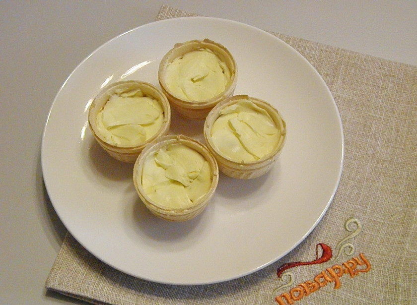 1. Этап. Тарталетки с красной икрой: Положите в каждую тарталетки по кусочку сливочного масла.