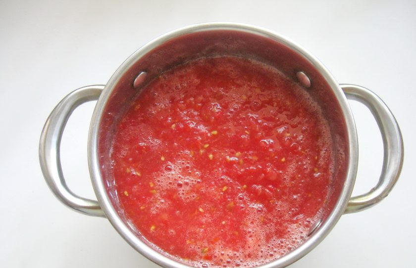1. Этап. Закуска из баклажанов с помидорами на зиму: Измельчите помидоры в мясорубке. Поставьте на огонь, доведите до кипения и варите на среднем огне 10-15 минут.