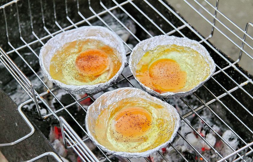 1. Этап. Яйца на гриле: Установите на мангале решетку. Поставьте сверху формочки из фольги и дайте им хорошо нагреться, затем выбейте в каждую по одному яйцу. Соль и перец используйте по вкусу. Жарьте яйца над раскаленными углями до желаемой степени готовности.