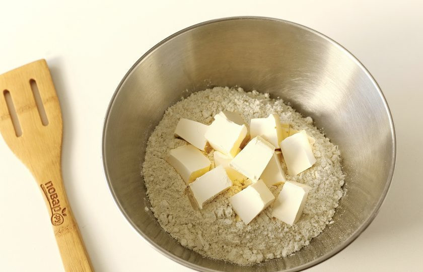 1. Этап. Печенье с тыквенными семечками: Переложите смесь в глубокую миску, добавьте нарезанное кубиками масло и соль.