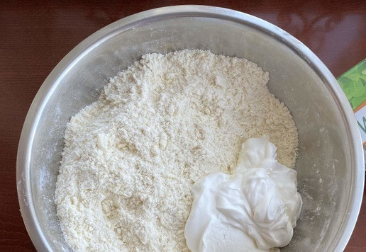 1. Этап. Самса Тюльпан: К мучной смеси добавьте сметану и замесите тесто.