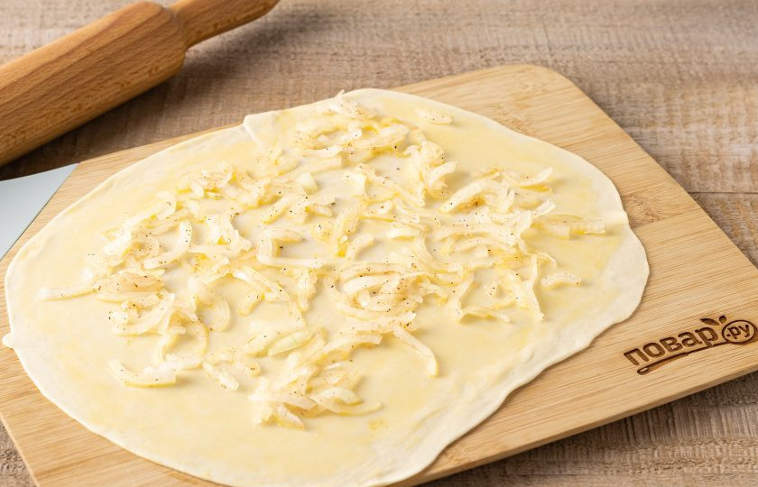 1. Этап. Слоёные лепёшки с луком Катлама: Смажьте пласт теста растопленным сливочным маслом. Выложите тонким слоем начинку из лука.