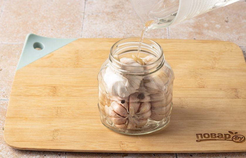 1. Этап. Маринованный чеснок по-азербайджански: Переложите головку чеснока в чистую стерилизованную банку. Маринад остудите до комнатной температуры, затем влейте в банку.