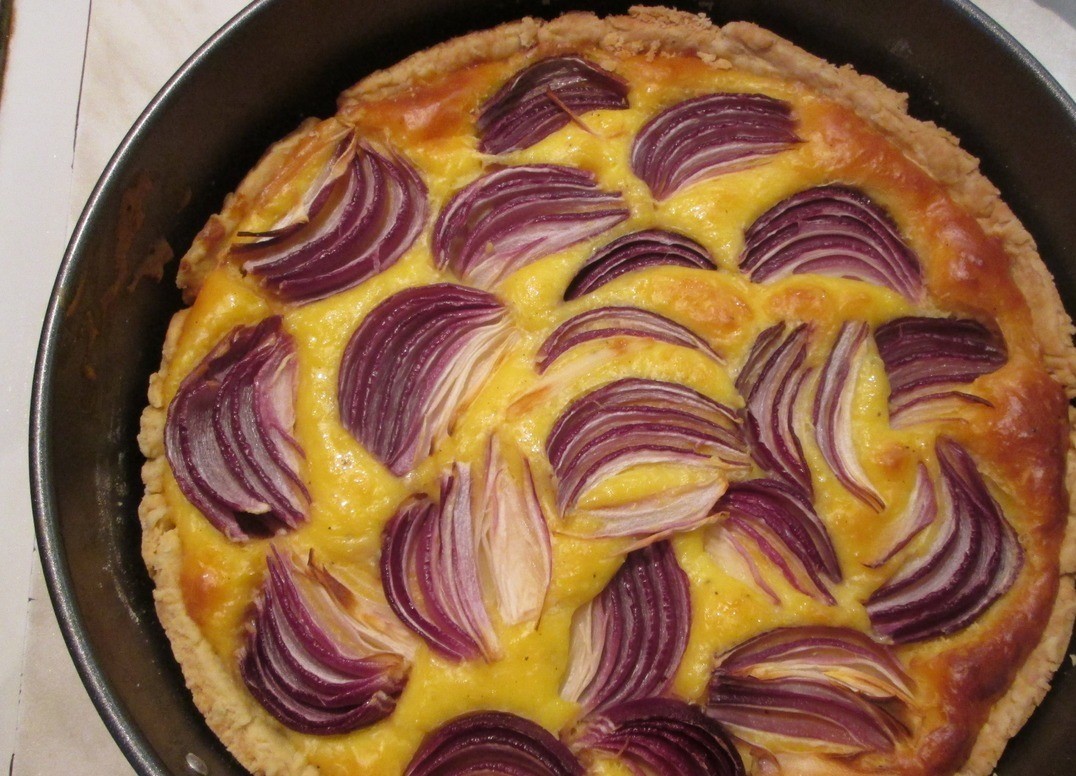 1. Stage. Red onion tart: Bake the base in a preheated 200 degrees oven for 5 minutes. Take out the mold, reduce the temperature to 180 degrees, and slightly cool the base. Cut onion into small slices. Pour the cream-cheese mixture into the tart base, top with onion slices, slightly pressing them in, pepper. Bake the tart at 180 degrees for 40-45 minutes.