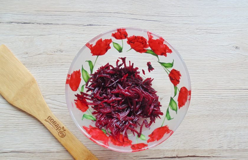 1. Этап. Салат со свеклой и копченым сыром: Свеклу вымойте, отварите и охладите. Очистите от кожуры и натрите на тёрке. У меня тёрка для корейской моркови. Переложите в салатник.