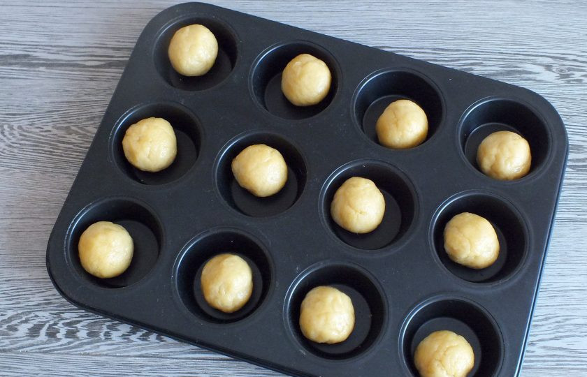 1. Этап. Тарталетки с орехами и карамелью: Когда начинка остынет, достаньте тесто из холодильника. Разделите его на 12-14 частей. Разложите в формочки.