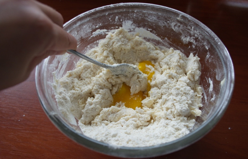 1. Этап. Печенье на кефире с вареньем: В полученную крошку добавляем яйцо и кефир. Замешиваем миксером тесто.