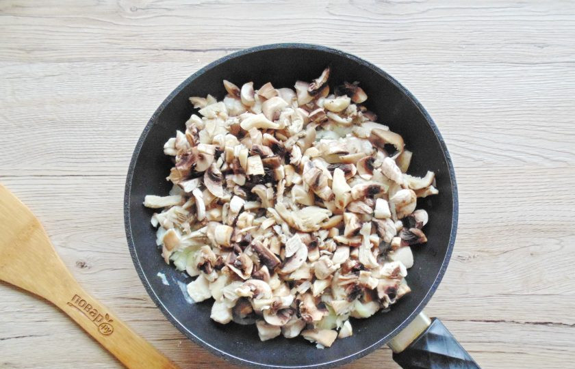 1. Этап. Жульен с курицей и грибами на сковороде: Грибы помойте, при необходимости очистите и нарежьте мелко. Выложите в сковороду к курице и луку. Посолите, поперчите.