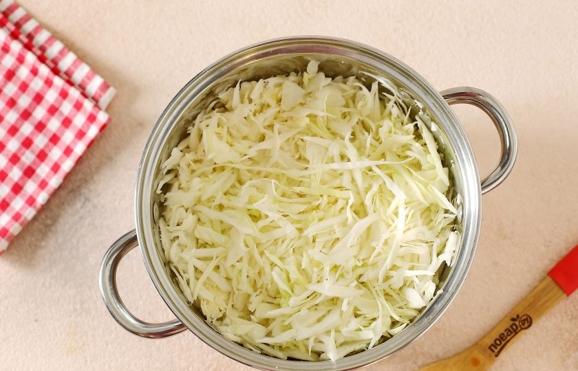 1. Этап. Капуста Бомба в горячем рассоле: Мелко нашинкуйте капусту и переложите в глубокую кастрюлю или таз.