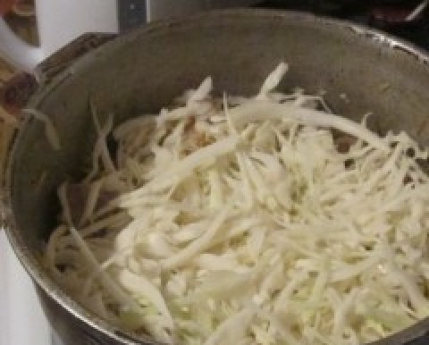 1. Этап. Бигус с мясом: Свежую капусту шинкуем, слегка солим и обжимаем. Отправляем в казанок. Самое время добавить перец и другие специи по желанию. Тушим минут 15 под крышкой.