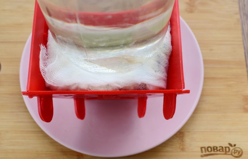 1. Этап. Пасха с печеньем Орео: В творожную массу добавьте кусочки печенья, перемешайте. Выложите массу в форму, накройте марлей, поставьте сверху блюдце и гнет. Это может быть банка с водой. Оставьте пасху в прохладном месте на 10-12 часов. Периодически сливайте из тарелки сыворотку.