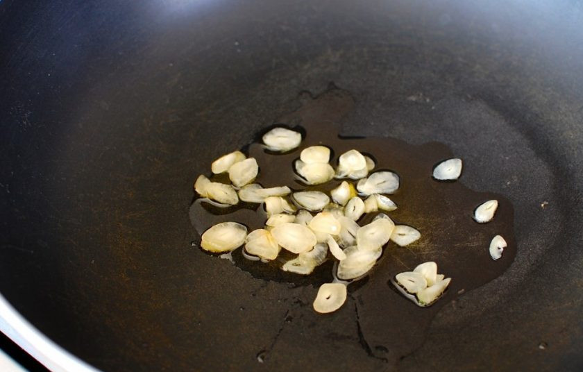 1. Этап. Маникотти из блинов с сырной начинкой: 6. В сковороде разогрейте оливковое масло. Нарежьте тонко чеснок и выложите его в масло, обжаривайте 1-2 минуты.