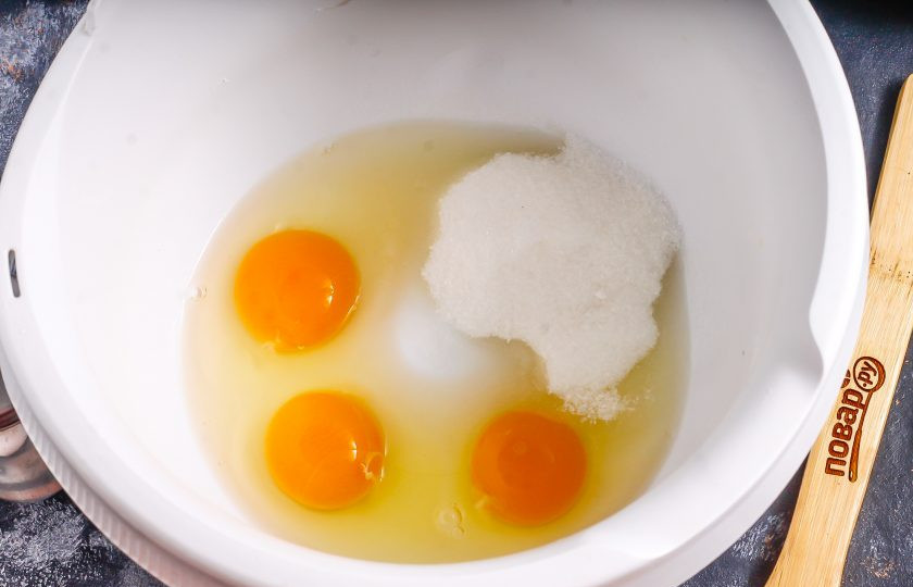 1. Этап. Творожный пирог со сливами: Вбейте куриные яйца в чашу кухонного комбайна, всыпьте соль и сахар, взбейте в течение 4-5 минут в пышную пену. Это можно сделать и миксером.