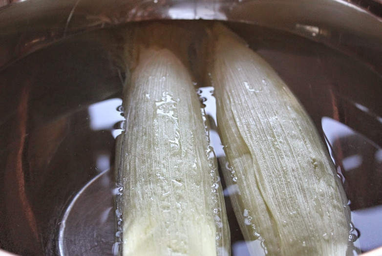 1. Этап. Cалат из кукурузы и курицы: Предварительно замочите кукурузные початки на 15 минут в холодной воде. Это делается для того, чтобы кукуруза лучше прожарилась на гриле и не подгорала.