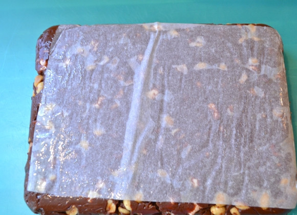 1. Этап. Шоколадные батончики с орехами: 4. После застывания аккуратно удалите застывший шоколадный пласт вместе с пергаментом, аккуратно снимите его.