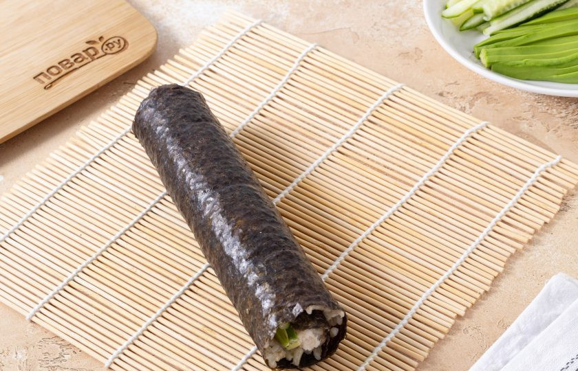 1. Этап. Роллы с бурым рисом: Смочите свободный край, аккуратно начните сворачивать ролл с помощью бамбукового коврика.