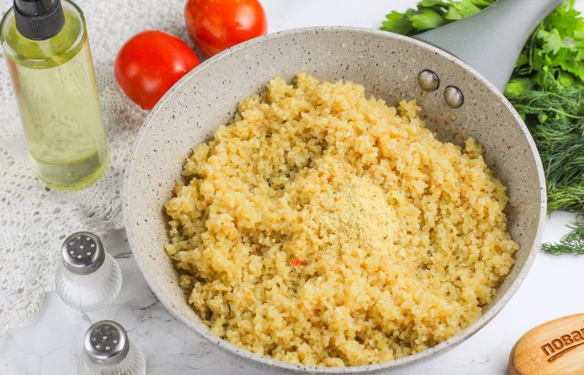 1. Этап. Булгур с беконом: Выложите поджаренный бекон из сковороды на тарелку и в сковороду всыпьте булгур. Размешайте, чтобы крупа впитала в себя мясной жир. Сразу же добавьте и приправу: универсальную или овощную.