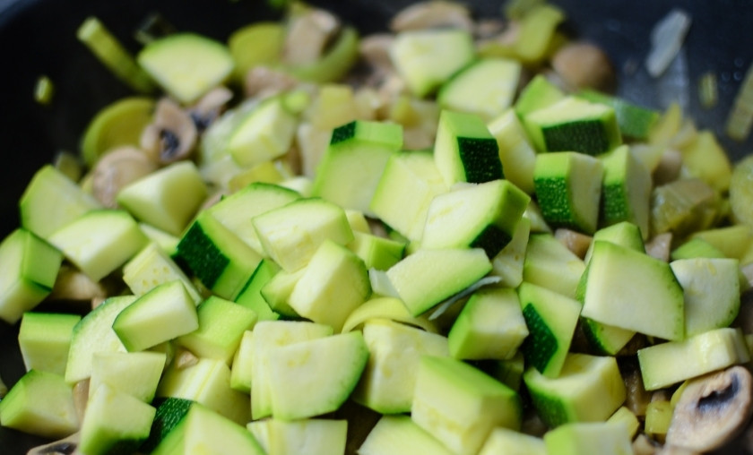 1. Этап. Блинчики с овощной начинкой: Добавьте к луку-порею и шампиньонам мелко нарезанные кабачки. Тушите всё вместе около 15 минут. Овощи должны стать мягкими.