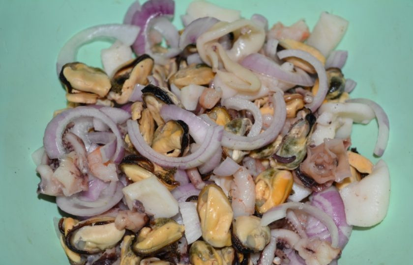 1. Этап. Морской коктейль в рассоле: Затем нарежьте полукольцами лук. Соедините его с морепродуктами.