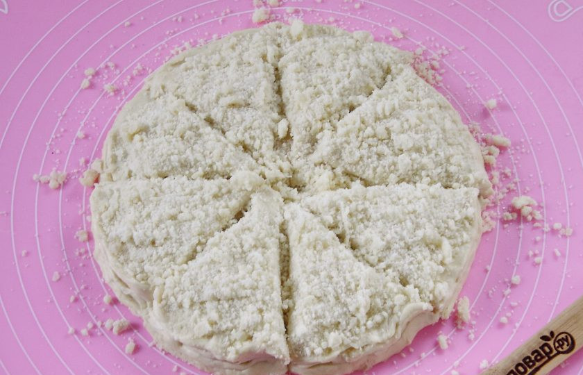 1. Этап. Слойки на кефире: Раскатайте следующий кусок теста и положите сверху, также посыпав крошкой и так далее по очереди. Верх у Вас должен быть посыпан крошкой. Разрезаем круг на 8-12 частей.