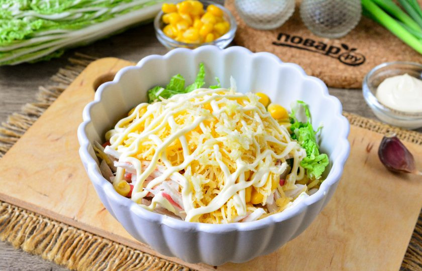 1. Этап. Салат с сыром, крабовыми палочками и пекинской капустой: Салат полейте майонезом и добавьте 1-2 зубчика измельченного чеснока. Посолите и поперчите по вкусу. Салат перемешайте.