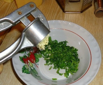 1. Этап. Хлеб с сыром в духовке: Зелень моем и мелко нарезаем. Очищаем чеснок и пропускаем через чеснокодавку. Если не хотите чеснок - можно обойтись и без него.