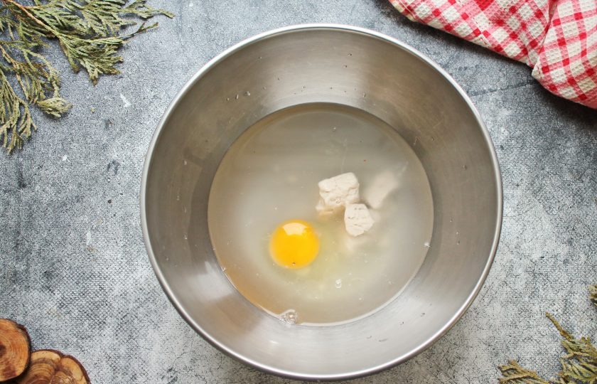 1. Этап. Лещ запеченный в тесте: В глубокую миску налейте теплую воду, добавьте соль, сахар, разбейте яйцо, раскрошите дрожжи и влейте растительное масло. Все хорошо перемешайте до растворения кристаллов и однородности.