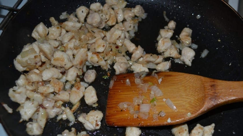 1. Этап. Картофельные ватрушки с курицей: К филе на сковороду добавьте измельчённый лук. Жарьте ингредиенты вместе пару минут, помешивая.