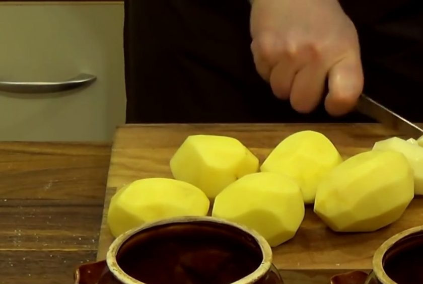 1. Этап. Картофель и мясо в горшочках: 2. Картофель очистите от кожуры и нарежьте небольшими кубиками. Сложите картофель в горшочки, посолите и залейте кипятком до половины горшочка.