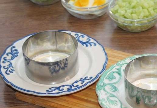 1. Этап. Слоеный салат с авокадо, тунцом, черри: 9. Берем 2 блюда и смазываем дно майонезом. Устанавливаем на блюдо формовочные кольца.