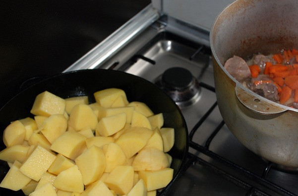 1. Этап. Жаркое по-домашнему из говядины: Далее нарезаем кубиками очищенный картофель и также отправляем его жариться на сковороду. Его не нужно жарить до готовности, а только лишь, пока на нем не образуется золотистая корочка.