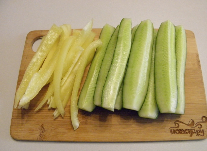 1. Этап. Пикантные огурчики на зиму: Овощи все тщательно вымойте. У огурцов срежьте попки. Сами же огурчики порежьте на 4-6 частей вдоль. Болгарский перец освободите от семян, промойте внутри и порежьте тонкими полосочками вдоль.