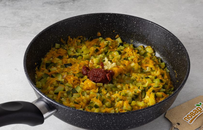 1. Этап. Икра из цукини: Добавьте измельченный чеснок и томатную пасту. Потушите еще пару минут, затем добавьте соль, сахар и черный молотый перец.