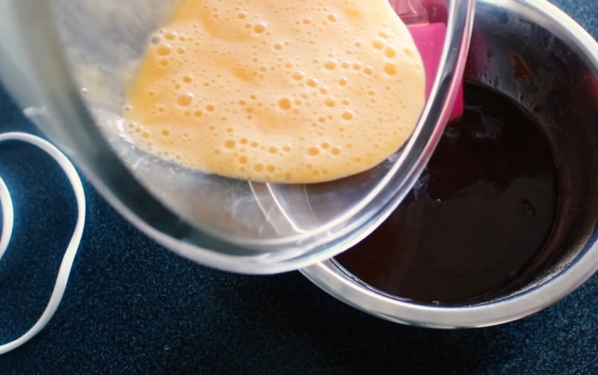 1. Этап. Брауни Елочки: 2. В отдельную емкость отправьте три яйца, совсем немного взбейте их с ванильным сахаром с помощью миксера. Половину яичной массы отправьте в слегка остывшую шоколадную массу и хорошо перемешайте лопаткой.