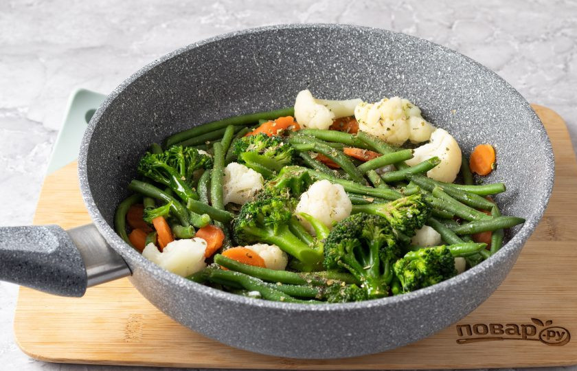 1. Этап. Замороженные овощи на сковороде: Когда испарится жидкость, влейте растительное масло, добавьте соль и специи по вкусу. Все перемешайте и обжарьте овощи пару минут до готовности.