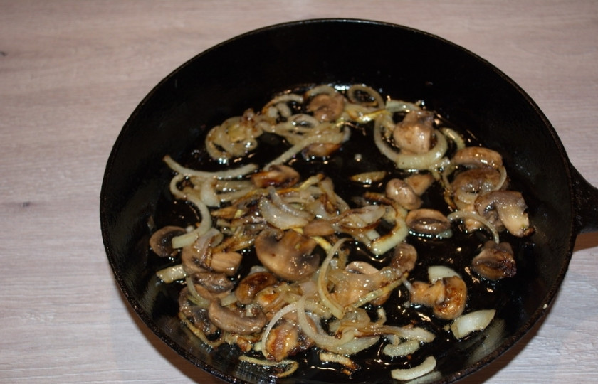 1. Этап. Скумбрия, запеченная с грибами: На растительном масле обжарьте лук до мягкости. Добавьте нарезанные грибы. Тушите все вместе, периодически помешивая, до готовности. В самом конце приготовления посолите и поперчите.