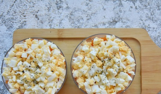 1. Этап. Салат с рисом и тунцом: Сверху на слой тунца распределяю тонким слоем лук. Следующим слоем раскладываю морковь. Заключительный слой из рубленных яиц. Салат заправляю подготовленной заправкой.