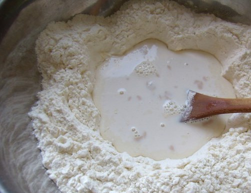 1. Этап. Быстрое сдобное тесто для пирожков: Сделайте посередине углубление, влейте туда разведенные дрожжи. Оставьте бродить, пока они не поднимутся 