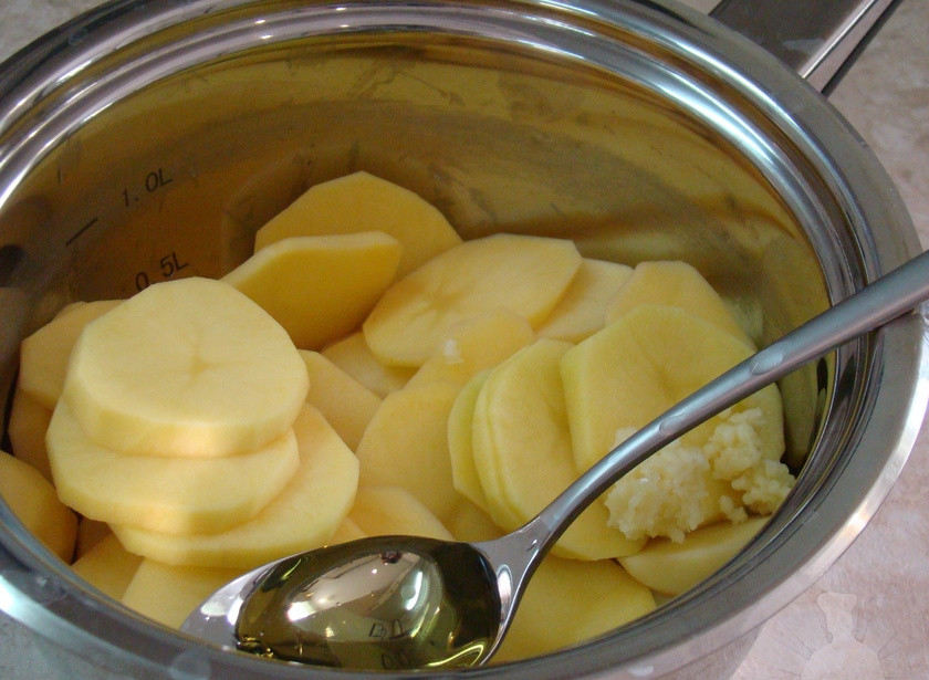 1. Этап. Картофель на гриле: Сложить картофель в просторную кастрюлю или миску. Добавить чеснок, соль, специи и масло, аккуратно перемешать и оставить минут на 5.