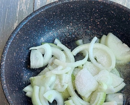 1. Этап. Двойной мясной бургер с карамелизированным луком: Добавить лук, нарезанный произвольно, соль и сахар.