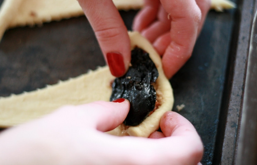 1. Этап. Рогалики с черносливом: Предварительно замочите в кипятке чернослив. Затем просушите его и выложите на сахар и орешки. Заверните рогалик.