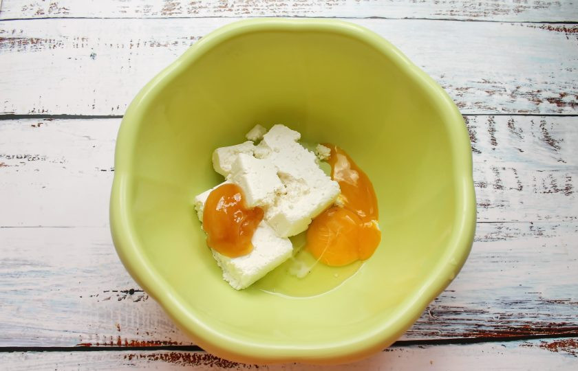 1. Этап. Ленивые вареники с малиной: В миску выложите творог, мед и разбейте яйцо. Все немного посолите и перемешайте до однородности.