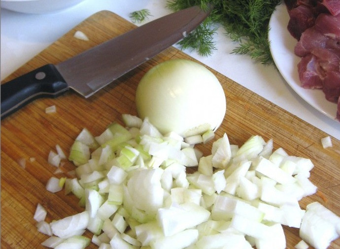 1. Этап. Свинина тушеная в горшочке: 4. Луковицу почистить и измельчить. Обжарить на растительном масле до золотистого цвета.