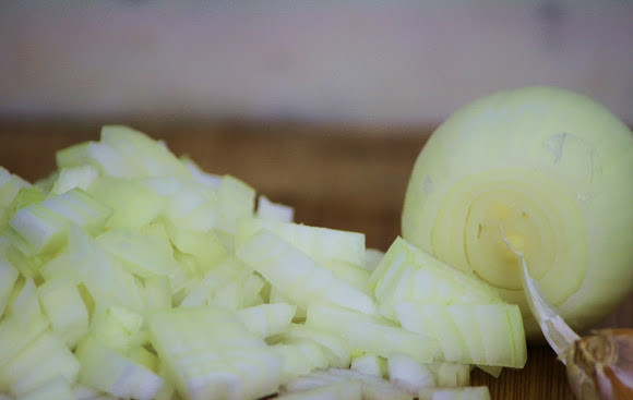 1. Этап. Долма по-азербайджански: 3. Почистите и нарежьте лук и чеснок и обжарьте на масле в сковороде на среднем огне до мягкости.