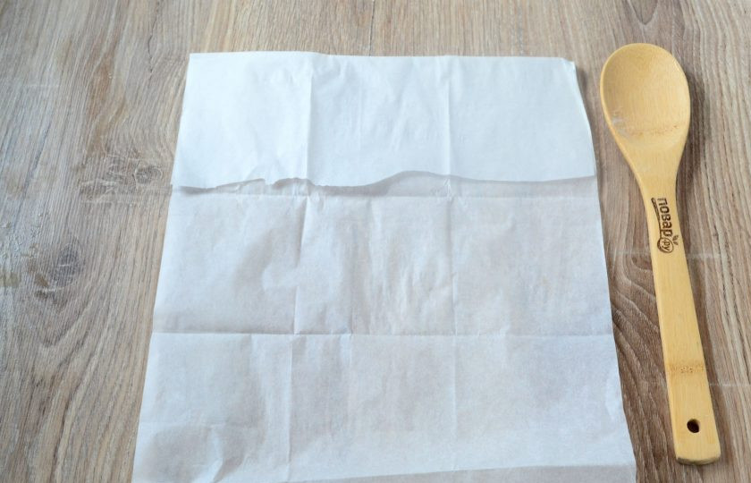 1. Этап. Кармашки с яблочными пирожками: Пока пирожки пекутся, сделайте для них конвертики из пергамента. Для этого возьмите лист пергамента примерно 30х40 см. Положите перед собой вертикально. Сверху примерно 1/5 часть подверните вниз.