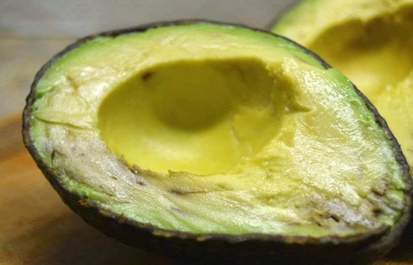 1. Этап. Фаршированный авокадо в духовке: 1. Разрежьте авокадо пополам, аккуратно удалите косточку.