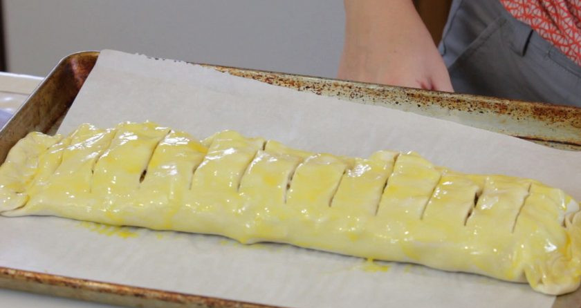 1. Этап. Яблочный штрудель с орехами: 5. Теперь выложите штрудель на противень. Сделайте надрезы сверху. Смажьте тесто взбитым яйцом.