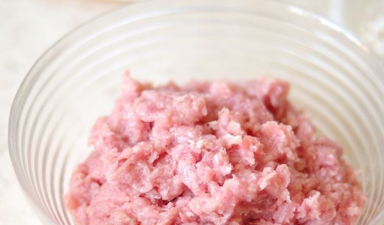 1. Этап. Ежики из фарша с рисом: Теперь вам необходимо сделать фарш, пока рис набухает. Для этого пропустите куриное филе через мясорубку вместе с чесноком, посолите и поперчите по вкусу.